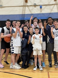 a group of boys posing for a picture on a basketball court